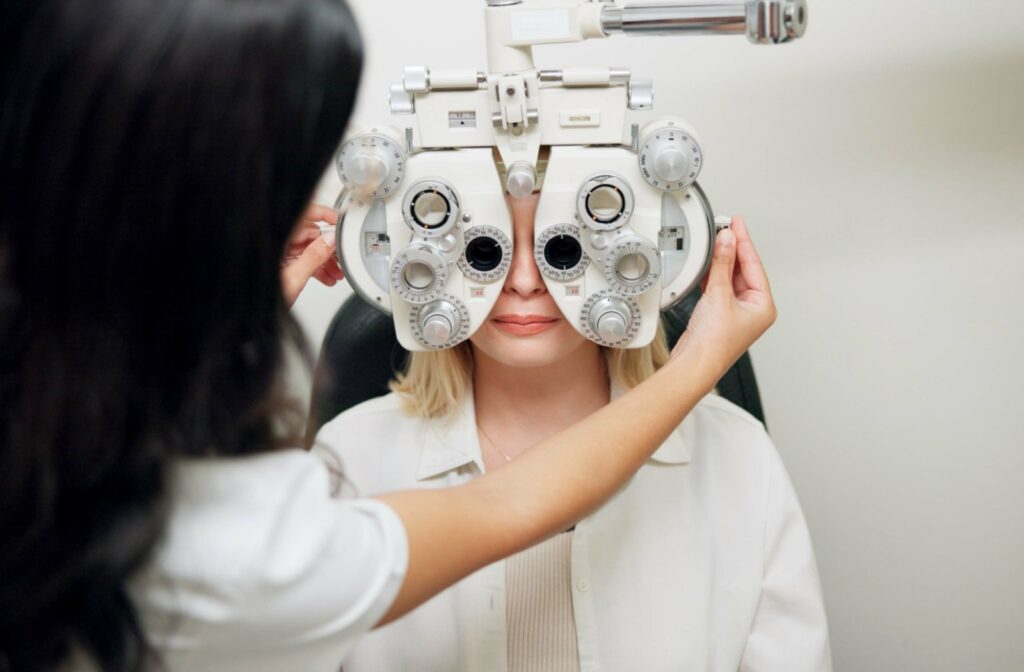 Patient undergoing eye exam with large diagnostic equipment partially covering their face.